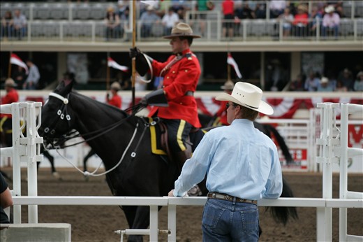 Cowboy observing the Royal Canadian Mounted Police at The Stampede