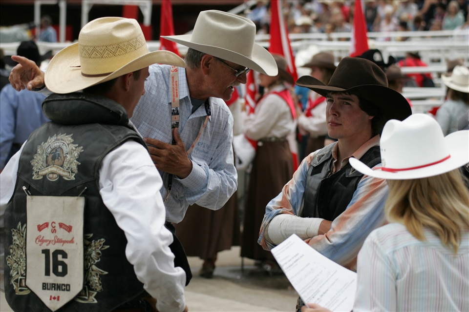 Rodeo riders and commentator exchange comments 