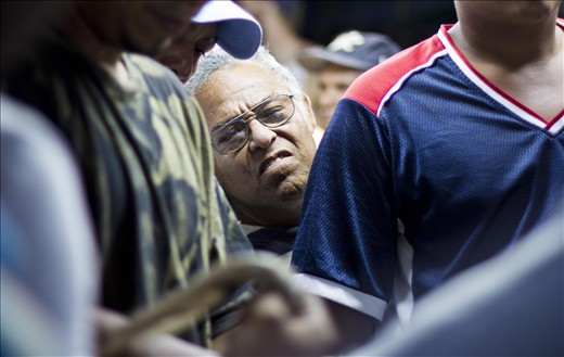 A spectator struggles to get a view of the roosters.