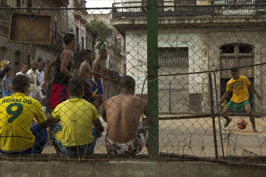 Here we can see some young men playing a friendly game of football together; they play on a makeshift soccer pitch that is nothing more than an empty concrete lot in central Havana. Cuba has a strong passion for sports, despite the lack of proper equipment and infrastructural resources much time is passed playing different sports on the Cuban streets.  