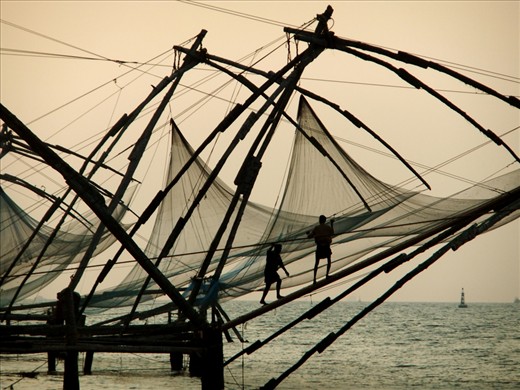 As the sun sets, two fishermen pull in the ropes after an unsuccessful day. 
The Chinese fishing nets (Cheena Vala) decorate the coastline of Fort Cochin, India, and have been used for hundreds of years to catch dinner for locals and the many tourists who flock the area.
