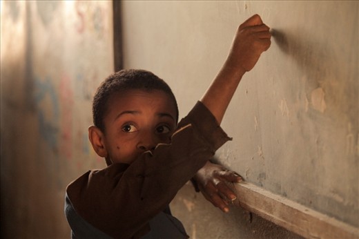 Education in primary school. A young boy learns to write. - in Hamusit Primary School Cluster Resource Center(grade 1 to 8 fully primary cycle).