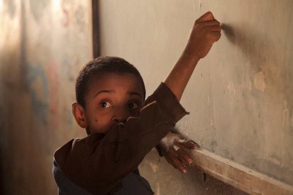 Education in primary school. A young boy learns to write. - in Hamusit Primary School Cluster Resource Center(grade 1 to 8 fully primary cycle).