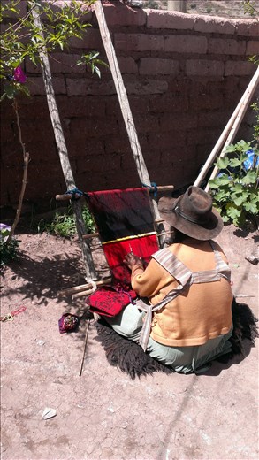 Sucre - local woman weaving in her yard in town in crater