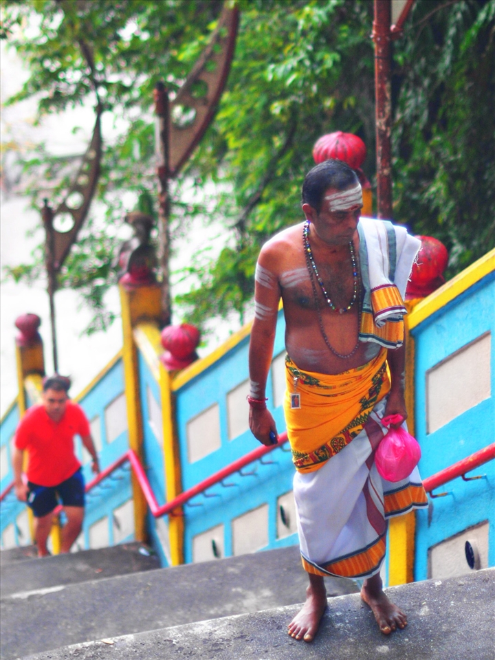 The Tamil worship against the tourist at the back climbing the stairway.
