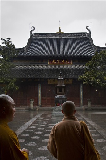 An older monk guides a young monk through Longhua Temple, Shanghai, China