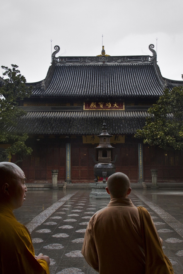An older monk guides a young monk through Longhua Temple, Shanghai