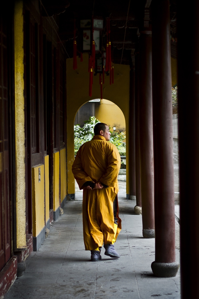 A monk strolls from building to building at Longhua Temple, Shanghai