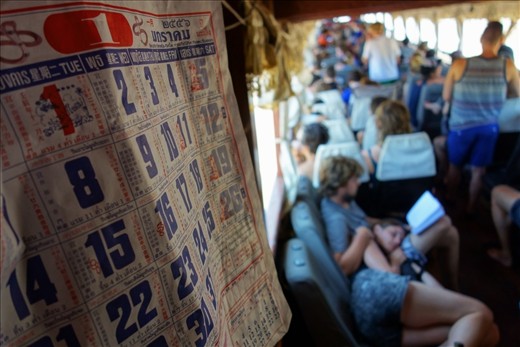 Tourists relax on the slow boat from Huay Xai to Luang Prabang during the low season in July, when heat and rain make travel more exhausting. To the locals, who refit their houseboats with car seats to ferry passengers, it's just another day on the river. The calendar is stuck on January.