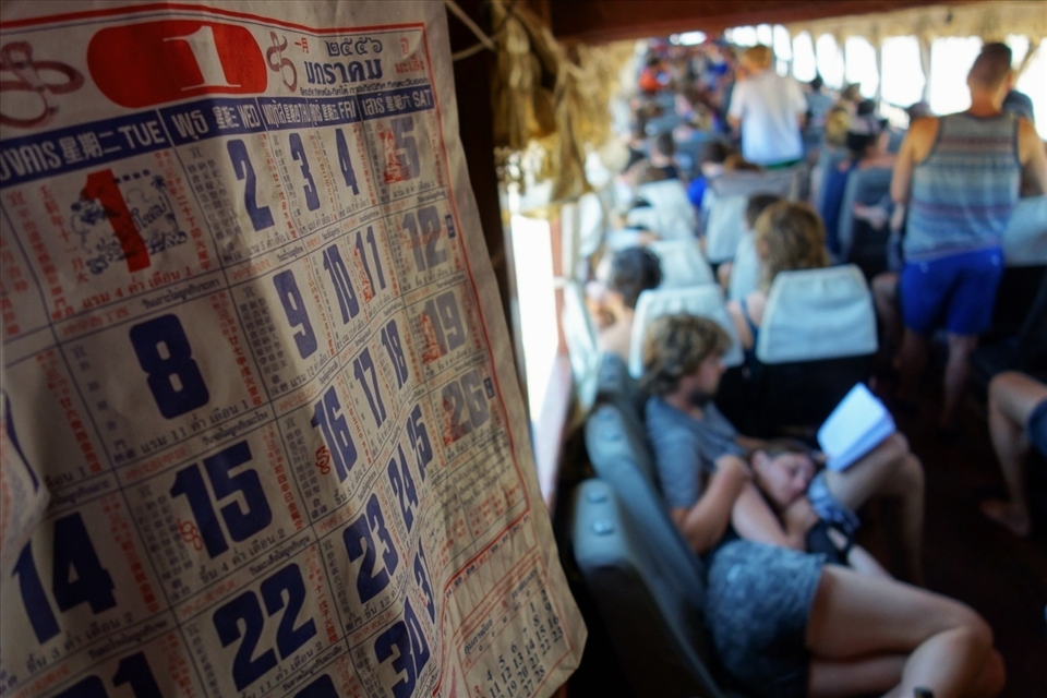 Tourists relax on the slow boat from Huay Xai to Luang Prabang during the low season in July, when heat and rain make travel more exhausting. To the locals, who refit their houseboats with car seats to ferry passengers, it's just another day on the river. The calendar is stuck on January.