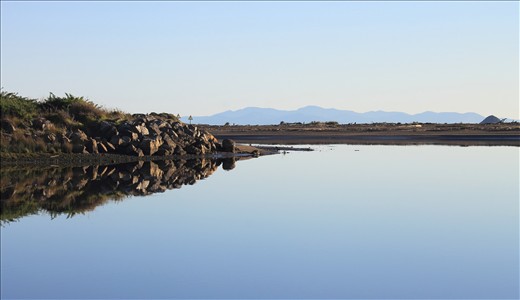Where the River Meets the Sea & Beyond, View from the Estuary composing North & South Islands of New Zealand in One.This nationally-significant reserve protects a natural mosaic of freshwater lakelets, saltwater lagoons and marshes, tidal sand flats and sandy beach at the mouth of the Waikanae River.
Foreground – Waikanae River Mouth opens to Waikanae Beach, North Island.
Middle Ground (far right) - Tahoramaurea Island (Browns Island), a small offshore Island at the Southern tip of offshore Native Bird Sanctuary, Kapiti Island, North Island.
Background – Marlborough Sounds, the north-easternmost point of the South Island. New Zealand. 