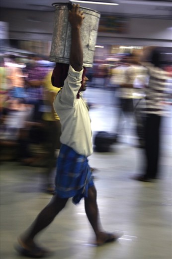 
Waiting for the Darjeeling Mail at Kolkata's Sealdah station, the atmosphere is hectic, as people run from one side to another. Here a man transports a container of food to a soon-to-depart train.