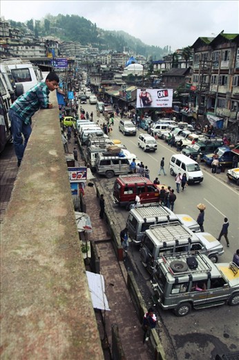At Darjeeling, a city hanging off a cliff in the nothern area of West Bengal, the most practical way to move around is by Jeep. Here a young boy calmly oversees the frantic activity going on in the main jeep stop, as people look for rides.