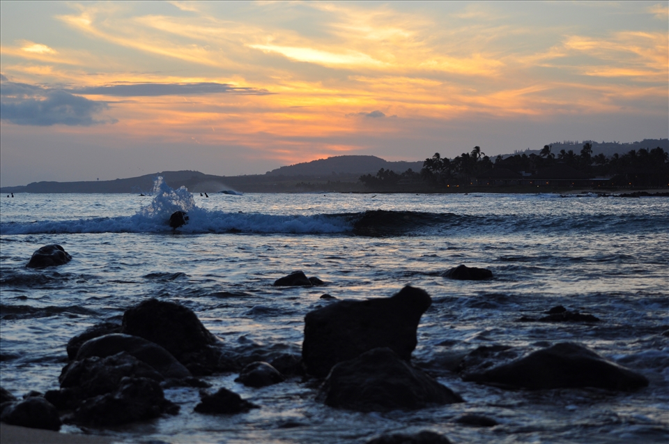 A spirit that focuses on the natural element, rather than the human element; in cohesion, rather than showing how humans impact nature, this shows how nature impacts humans. If focus is directed towards the background elements of the photo, surfers silhouettes are shown waiting for the perfect wave; for hours they sit waiting to be granted that one flawless entity that permits them the freedom to walk on water; the nightfall--the kiss of the sun on the mountains, the caress of the waves on the rocky shore--highlights the perfect timing for this perfect event. 