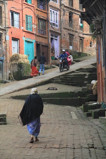 One of the main streets of the medivial town of Bhaktapur. The cobblestone streets and colorful houses compose a classic scene of the town.