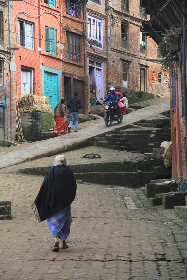 One of the main streets of the medivial town of Bhaktapur. The cobblestone streets and colorful houses compose a classic scene of the town.