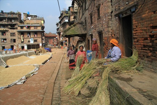 The city streets are full of grains of rice, with women trying to dry it and to sort it out. In the background of the photo, we can see the eastern entrance to the town.