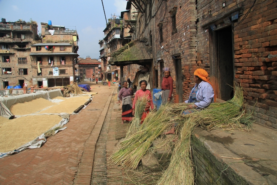 The city streets are full of grains of rice, with women trying to dry it and to sort it out. In the background of the photo, we can see the eastern entrance to the town.