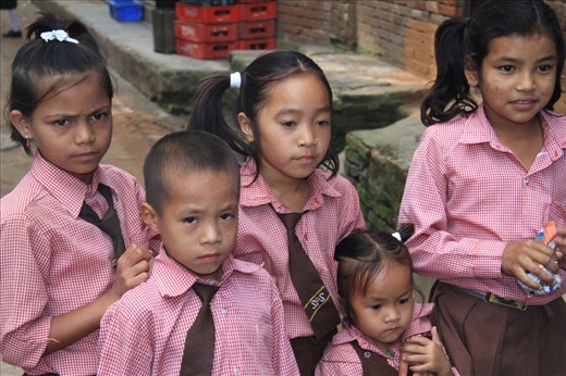 The children dressed in school uniforms have just finished the courses and casually wander around the streets.