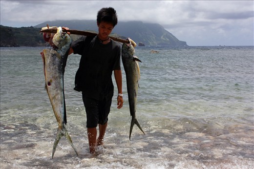 A son carries his father's catch of the day.