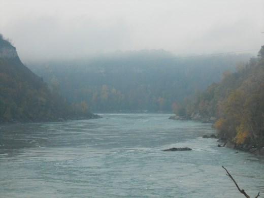 Niagara River from ground level, slipping over rocks along the pre-dawn edge. 