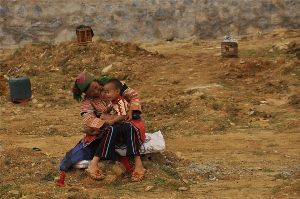 During noisy market day, when I was overwhelmed by the variety of colors, smells and sounds of everything there , wife of one of bird sellers was playing with child, seemed like she didn’t hear all the buzz around her.