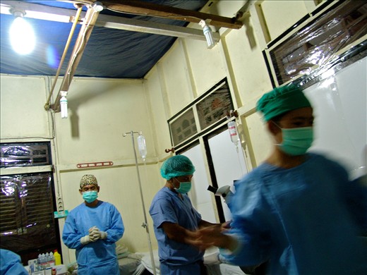 Missionary Dr. Eddie prays in between the flux of patients. Every year Dr. Eddie and Dr. Steve travel to various areas of Indonesia offering  free cataract surgeries to remote communities in need. At ASRI Medical Clinic, they are not allowed to proselytize.  Often working late into the evening, within four days, they operate on 90 patients.  Both doctors work in the same room and nurses often sit on the operating beds in order to properly distribute sterilized surgical instruments.  Plastic tarps line the ceiling and widows, offering a modest barrier to the humidity, heat and bugs of the Borneo jungle.  