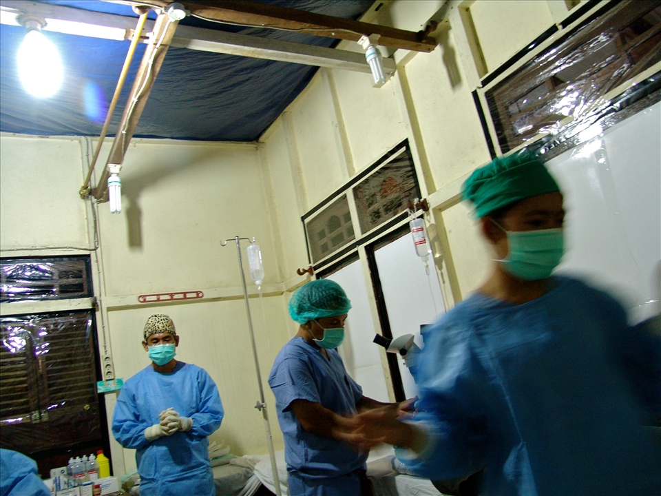 Missionary Dr. Eddie prays in between the flux of patients. Every year Dr. Eddie and Dr. Steve travel to various areas of Indonesia offering  free cataract surgeries to remote communities in need. At ASRI Medical Clinic, they are not allowed to proselytize.  Often working late into the evening, within four days, they operate on 90 patients.  Both doctors work in the same room and nurses often sit on the operating beds in order to properly distribute sterilized surgical instruments.  Plastic tarps line the ceiling and widows, offering a modest barrier to the humidity, heat and bugs of the Borneo jungle.  