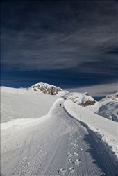 I was attempting to discover the mountains beyond the ski resort in Val D'isere, France. I had taken the ski lift up Le Fornet and had taken the hikers path over the mountain. As I passed a man, I turned around to watch his ascent up the path. There were no skis here. I don't know where he came from or where he was going but I was compelled to take his photograph as he continued his journey round the mountain. : by katielongleyphotography, Views[359]