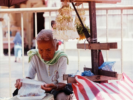 An old lady contemplates on her food. Taking a break from work.
