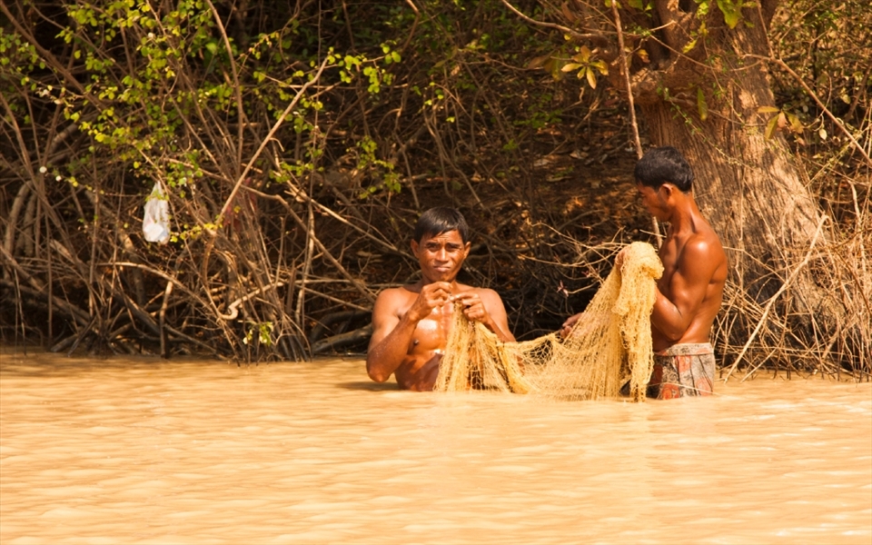 It is mid-afternoon and despite the heat, the men wade out into the lake to check the nets and see what is going to be 'catch of the day'.