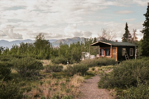 A cabin sits on the shore of Kluane Lake. Scientists working at the Kluane Lake Research Station during the summer sleep in these basic cabins. Although they protect the researchers from the grizzlies that share the base with them in the late summer, the cracks in the plywood don't keep out the plentiful mosquitos. 