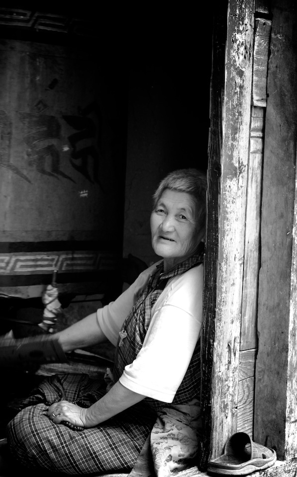 The old lady at Kyichu Lhakhang: Bhutan offers shelters inside temples, chortens, stupas and monasteries for its older citizens to rest or sleep during the day. At Kyichu Lhakhang, one of the countries oldest temples, I found her whispering something funny about me to her fellow shelter seekers. Maybe because I had the camera pointed straight at her. Her instant reaction of making fun of me taught me one of the most important things I learnt about portrait or travel photography - engaging with the moment. I sat with her then, unable to understand her language, and she talking continuously to me as if it didn't matter I couldn't understand her. Bhutan's Gross National Happiness formula fully executed, I had thought in my mind then. I took this shot of her after taking her permission as I left the temple.