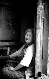 The old lady at Kyichu Lhakhang: Bhutan offers shelters inside temples, chortens, stupas and monasteries for its older citizens to rest or sleep during the day. At Kyichu Lhakhang, one of the countries oldest temples, I found her whispering something funny about me to her fellow shelter seekers. Maybe because I had the camera pointed straight at her. Her instant reaction of making fun of me taught me one of the most important things I learnt about portrait or travel photography - engaging with the moment. I sat with her then, unable to understand her language, and she talking continuously to me as if it didn't matter I couldn't understand her. Bhutan's Gross National Happiness formula fully executed, I had thought in my mind then. I took this shot of her after taking her permission as I left the temple.: by kavyanjali, Views[750]