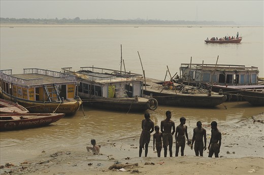 During a really heavy rain in Varanasi, a group of boys were scouring the riverbank of Ganga for whatever they can find useful that were washed off by the water current from the city. After the treasure hunt, the boys somehow gathered up. It's quite curious what they're up to, probably concerning how each other did on their hunt. 