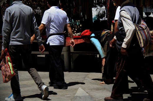A woman from Tibet Buddhism was praying by lying all her body on ground.