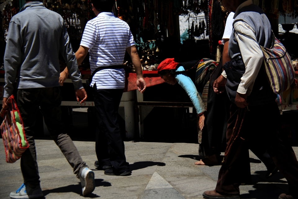 A woman from Tibet Buddhism was praying by lying all her body on ground.