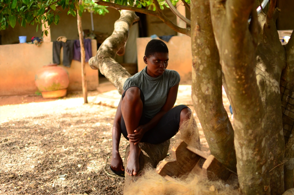 Eldest daughter Filo, watches on as her mother sells fish to nearby villagers.