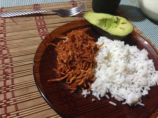 Mexican chicken dish con onions y garlic, arroz, aguacate