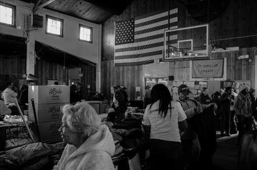Rockaway Beach, NY: The gymnasium behind St. Camillus and St. Virgilius Parish had been turned into a place for residents to restock on the necessities. Narrow aisles snaked through tables of clothing and food donated by people and various organizations. People could pick up anything from hot food to warm clothing. It was organized by the Occupy Sandy movement. Hurricane Sandy caused over $63 billion USD in damage across the United States on October 2012.
