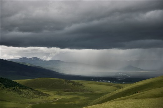The quiteness in the endless green valleys around Litang, spotted by herd of yaks on the hills, is only broken by a summer storm.
