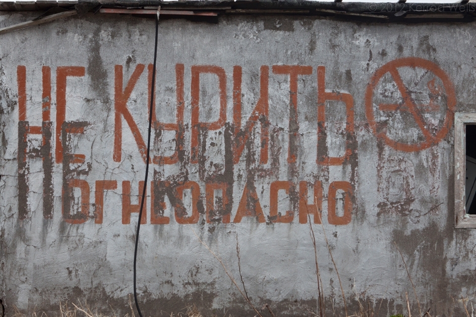 A warning that should not be taken lightly. Smoking around fuel being pumped to the submarines at the floating docks would have been hazardous to one's health. Simushir Island, Russian Far East
