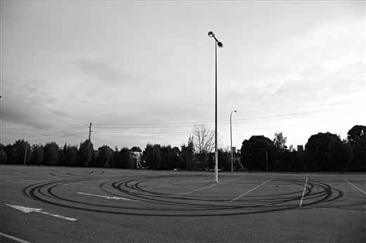 This series of photographs investigates altered perceptions of place over time. Every time I re-visit the town I grew up in it feels different. The modest suburban town has always been of lower socio-economic value and hasn’t been able to shake its abrasive reputation. 'New donut marks around a pole in a car park that used to be a common location for late night drag races.'