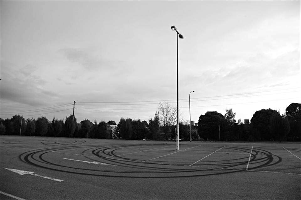 This series of photographs investigates altered perceptions of place over time. Every time I re-visit the town I grew up in it feels different. The modest suburban town has always been of lower socio-economic value and hasn’t been able to shake its abrasive reputation. 'New donut marks around a pole in a car park that used to be a common location for late night drag races.'