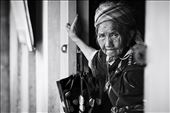 A Hmong Grandmother rests her hands against a door after a long journey through the mountainous region of Sapa. She is carrying her granddaughter in her left arm with the aid of a homemade baby carrier.: by kien, Views[353]