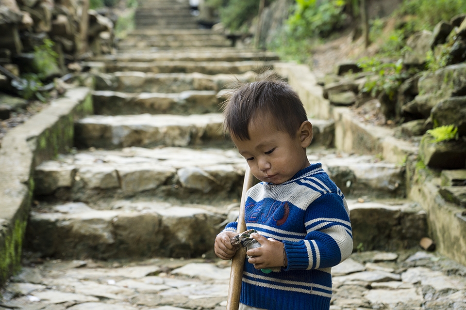 A local Hmong boy ponders at a granola bar that was given to him by a friendly visiting tourist. 