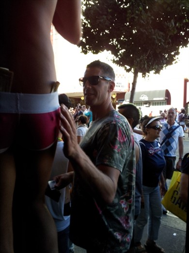 Got a dollar:  The sexually charged nature of the event is obvious and this dancer is enjoying showing his body with a passerby showing his appreciation. 