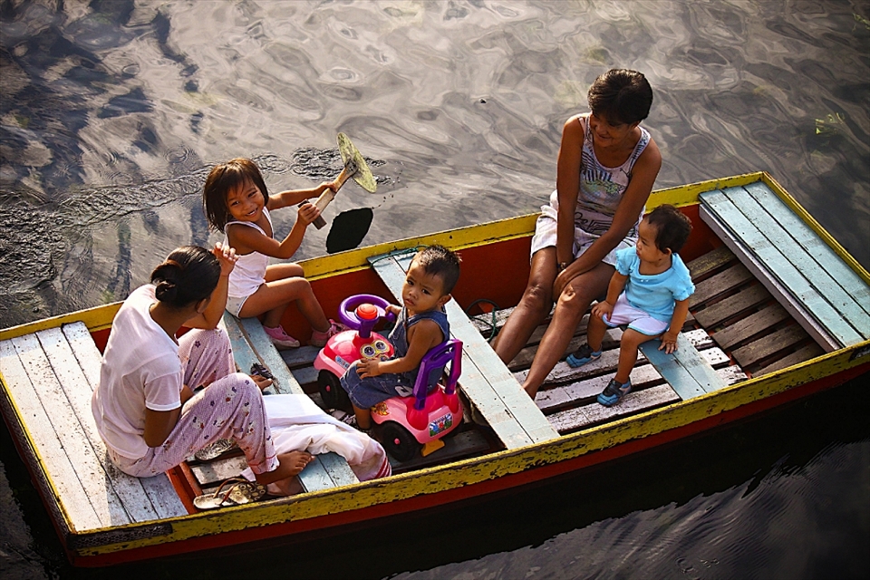 This family enjoys a morning boat ride. Despite their living condition, the residents cannot be seen unhappy. 