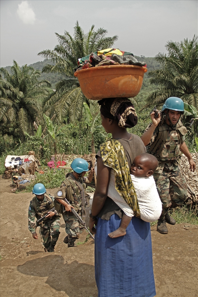 Mum, baby, blue halmets and dirthy clothes. A rutinary day in the village.