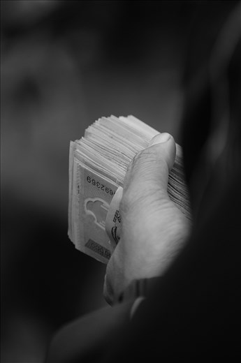 Men crowd around carrying years of savings,  $1400, to make their purchase.